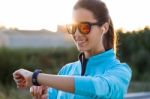 Portrait Of Young Woman Using They Smartwatch After Running Stock Photo