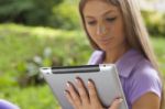 Woman With Tablet Computer In Park Stock Photo