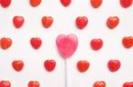 Pink Valentine's Day Heart Shape Lollipop With Small Red Candy In Cute Pattern On Empty White Paper Background. Love Concept. Colorful Hipster Style. Knolling Top View Stock Photo