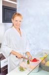 Woman Making Fruit Salad In Kitchen Stock Photo