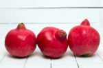 Fresh Pomegranate Fruits Isolated On A White Wooden Background Stock Photo