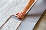 Handyman's Hands Laying Down Laminate Flooring Boards Stock Photo