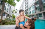 The Kid And Mom Play Together In The Pool Stock Photo