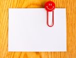 Close Up Of A  Red Paper Clip And White Paper On Wood Table Stock Photo