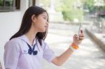 Portrait Of Thai Student Teen Beautiful Girl Using Her Phone And Smile Stock Photo