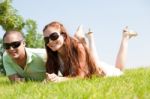 Beautiful Young Couple Lie Down On Grass Stock Photo