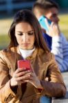 Young Couple With Smartphones In The Park Stock Photo