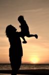 Silhouette mom with child at sunset Stock Photo