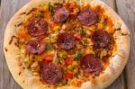 Delicious Baked Salami Pizza Served On Rustic Wooden Table Stock Photo