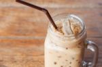 Glass Of Iced Coffee On Wooden Table With Vintage Filter Style Stock Photo