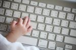 Close-up Of A Baby's Hand Using Keyboard Stock Photo