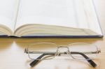 Close Up Glasses And A Book On The Desk Stock Photo