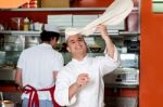 Chef Throwing Up Thin Base Dough Stock Photo