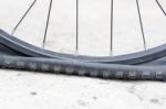 Bicycle Wheel With Flat Tyre On The Concrete Road Stock Photo