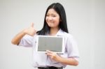 Portrait Of Thai High School Student Uniform Beautiful Girl Using Her Tablet Stock Photo