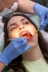 Dentist Curing A Female Patient Stock Photo