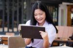 Portrait Of Thai High School Student Uniform Beautiful Girl Using Her Tablet Stock Photo