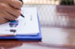 A Business Man Is Using A Pen To Write On The Paper Reported Stock Photo