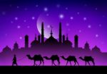 Caravan Of Camels In The Desert Near The Mosque Under The Moon Stock Photo