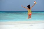 Happy Young Woman Jumping On The Beach Stock Photo