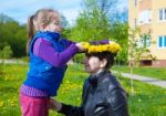 Daughter Puts On Her Mom's Head A Wreath Of Dandelions Stock Photo