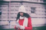 Woman In Red Coat With Smartphone In Hands Going Through The Cit Stock Photo