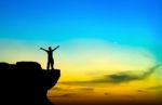 Silhouette Of A Man On The Rock At Sunset Stock Photo