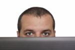 Man Peeking Over Laptop Stock Photo