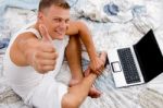 Young Man With Thumbs Up And Laptop Stock Photo