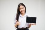 Portrait Of Thai High School Student Uniform Beautiful Girl Using Her Tablet Stock Photo