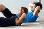 Couple Doing Push Ups Near The Sea Stock Photo