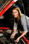 Young Female Trainee Fixing Car Engine In Garage Stock Photo