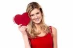 Smiling Teen Girl Showing Heart Shape Gift To Camera Stock Photo