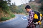 Tourists Man Look At A Map On The Tablet On Mountain Roads Stock Photo