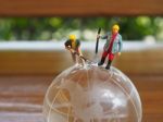 Miniature Businessman Stand On Globe Of Glass With Wooden Backgr Stock Photo