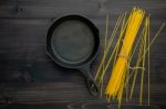The Thin Spaghetti On Black Wooden Background. Yellow Italian Pa Stock Photo
