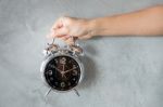 Woman Hand On Alarm Clock Stock Photo