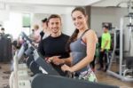 Happy Coach Assisting Young Woman In A Gym Stock Photo