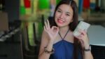 Portrait Of Thai Adult Beautiful Girl Using Her Smart Phone And Smile Stock Photo