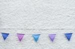 Colorful Party Flags Bunting Hanging On White Wall Background. Minimal Hipster Style Design Stock Photo