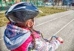 Little Girl In A Safety Helmet Riding A Bicycle Stock Photo