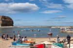 People Enjoying Themselves In Staithes Harbour North Yorkshire Stock Photo