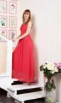 Young Woman In Red Dress Standing On The Stairs Stock Photo