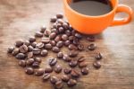 Coffee Beans With Coffee Cup On Wooden Table Stock Photo