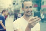 Young Man With Cell Phone Walking Stock Photo