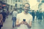 Smiling Man With Cell Phone Walking Stock Photo