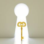 Golden Key Into A Gate Shaped Like A Keyhole Stock Photo