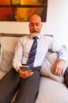 Middle-aged Businessman Listening On Smartphone At Home Stock Photo