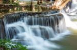 The Water Flowing Over Rocks And Trees Down A Waterfall At Huay Mae Khamin Waterfall National Park ,kanchana Buri In Thailand Stock Photo