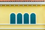 Four Green Arched Windows On Yellow Wall Stock Photo